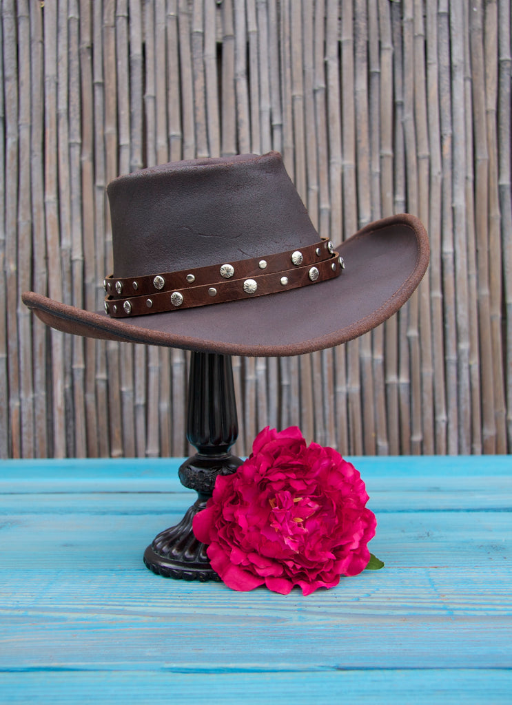 dark brown distressed double strap studded hat band on leather cowboy hat with bamboo background