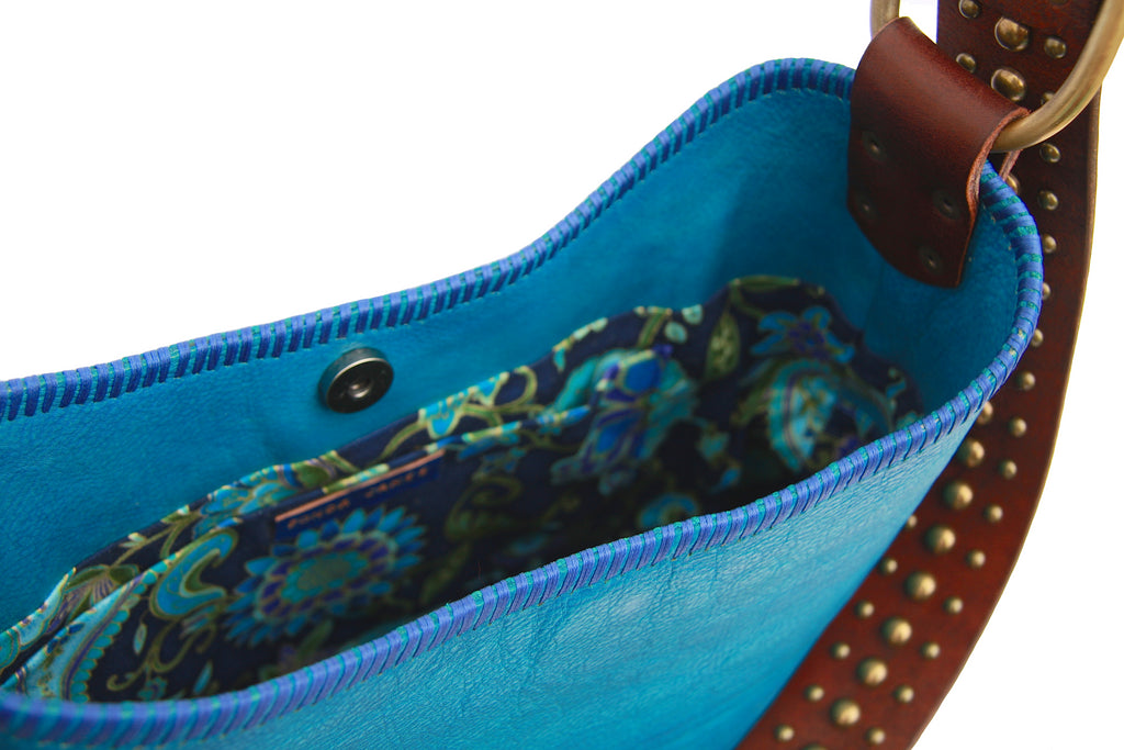 peacock blue purse with green blue and turquoise color floral lining close up