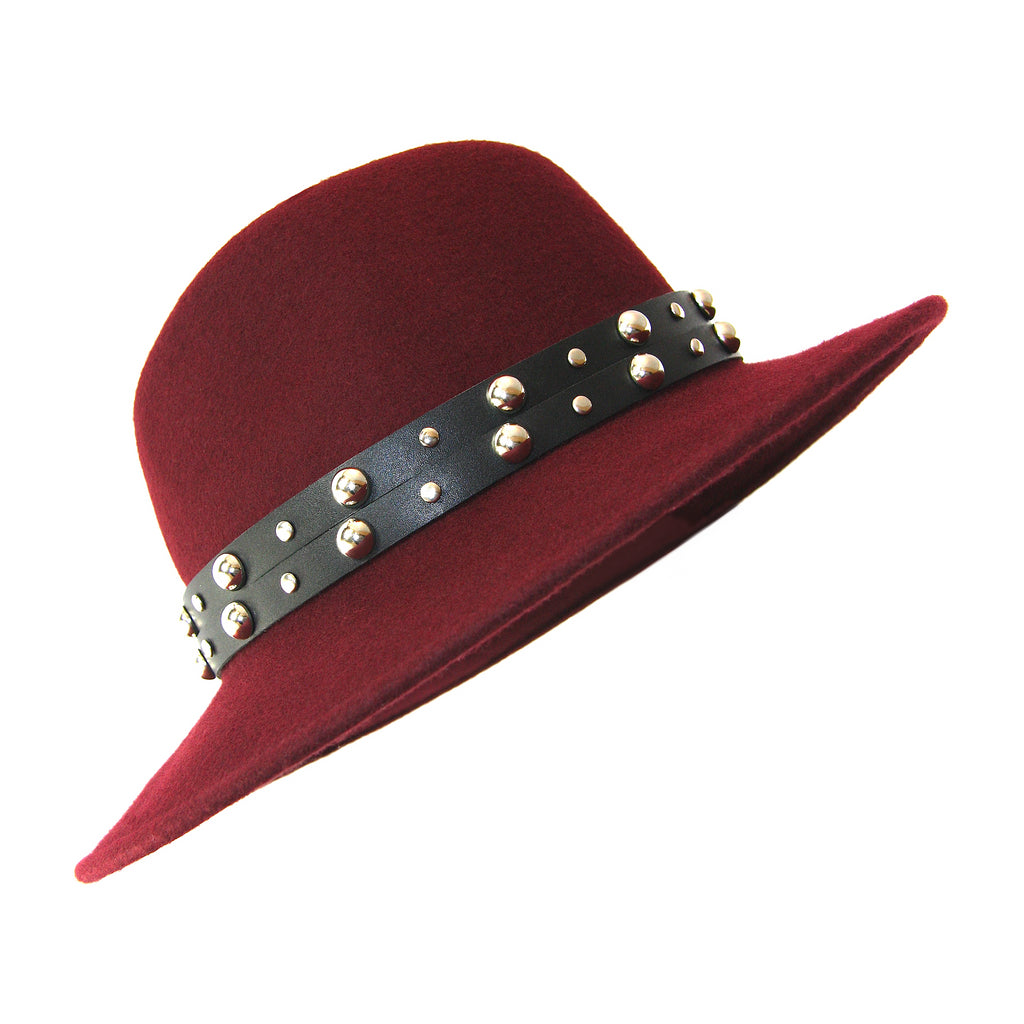 Red fedora with black leather double strap studded hat band in front of white background 