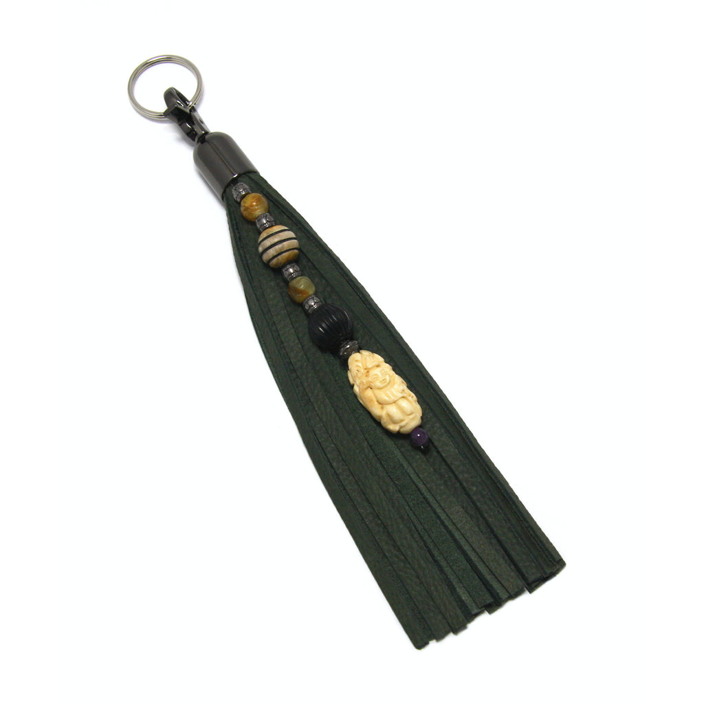 olive green leather beaded tassel key fob with bone good fortune netsuke and semi precious stones with white background