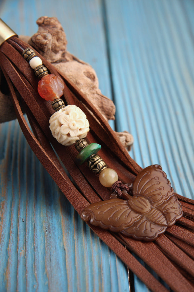 brown Nephrite Jade butterfly beaded leather tassel key fob close up blue background