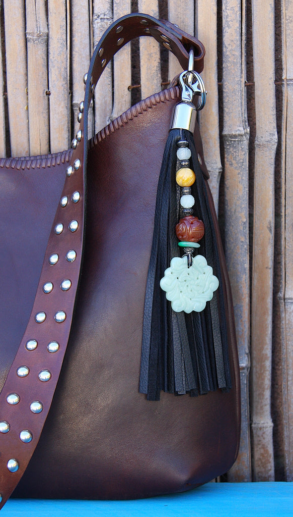 beaded black leather tassel key fob purse charm with large jade floral pendant clasped to handmade brown leather shoulder strap handbag