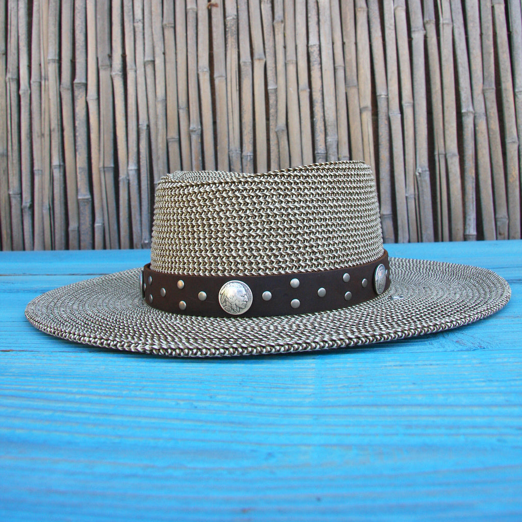 straw hat with buffalo nickel conch studded brown hatband on Blue wood table and bamboo background
