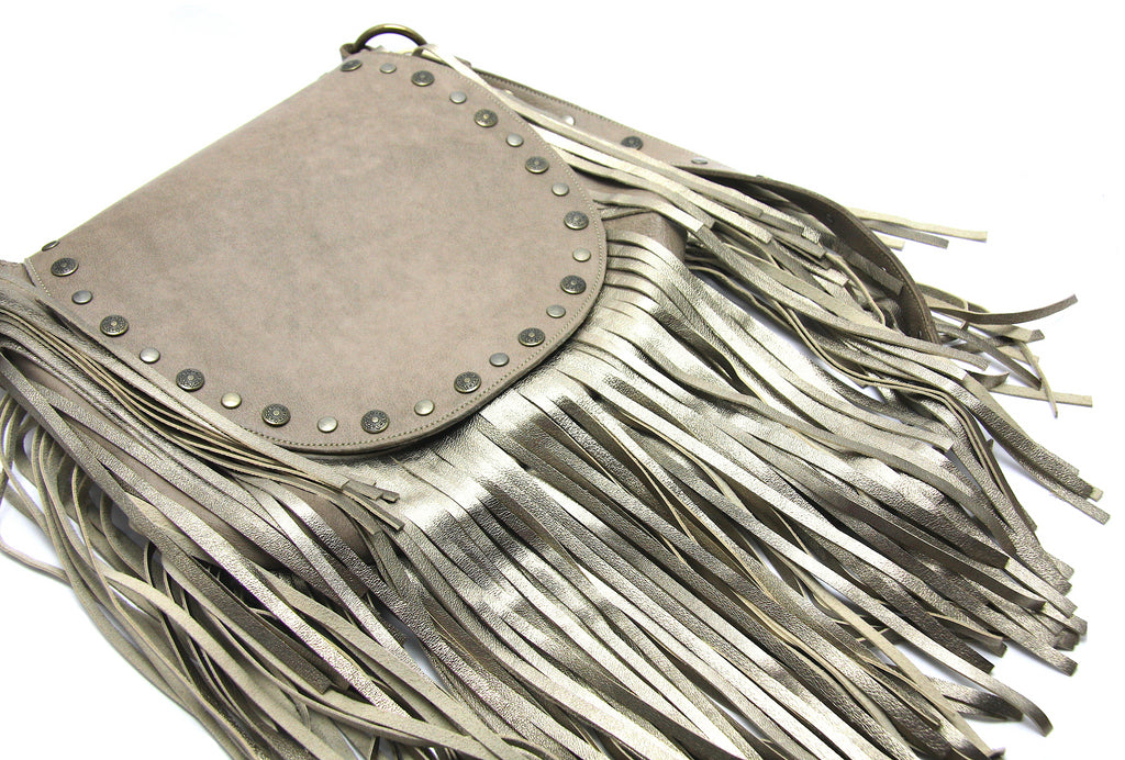 Beige flap shoulder strap handbag with matching metallic fringe on front and sides flap has antiqued brass studs along edge