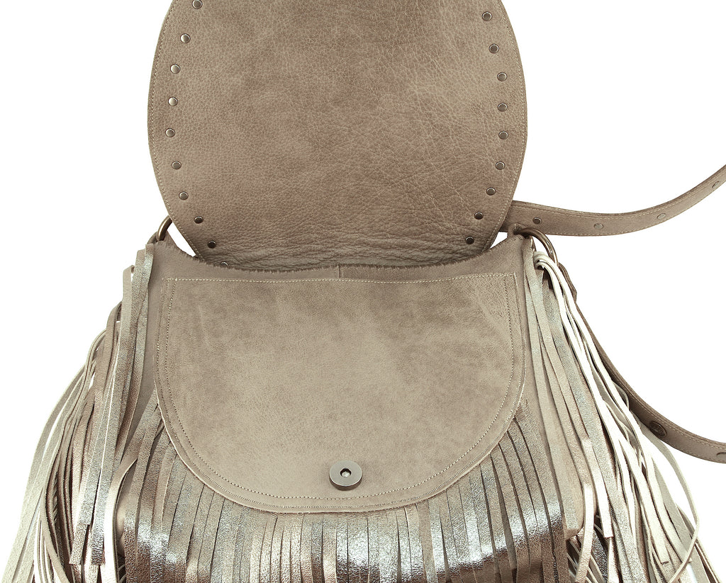 Beige bohemian saddle bag  with metallic fringe front flap open showing pocket in front 
