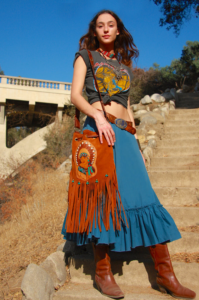 bohemian woman wearing Tan fringe handbag with hand tooled indian chief design on front